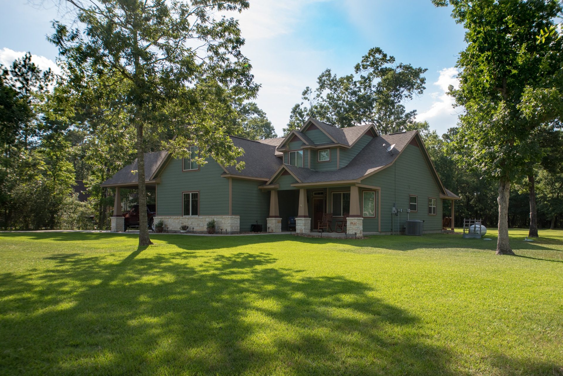 Custom craftsman home nestled among mature trees at White Oak Trails